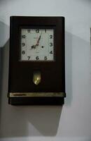 Old wall clock in dark wooden box photo