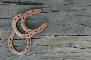 antiguo oxidado herraduras en rústico madera con sitio para texto foto