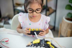 STEM education concept. Asian students learn at home by coding robot arms in STEM, mathematics engineering science technology computer code in robotics for kids' concepts photo