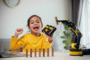 STEM education concept. Asian students learn at home by coding robot arms in STEM, mathematics engineering science technology computer code in robotics for kids' concepts. photo