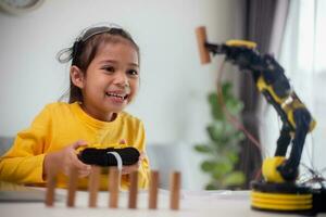STEM education concept. Asian students learn at home by coding robot arms in STEM, mathematics engineering science technology computer code in robotics for kids' concepts. photo