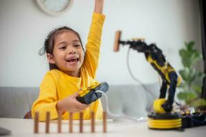 STEM education concept. Asian students learn at home by coding robot arms in STEM, mathematics engineering science technology computer code in robotics for kids' concepts. photo