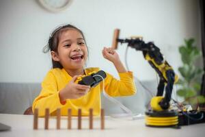 STEM education concept. Asian students learn at home by coding robot arms in STEM, mathematics engineering science technology computer code in robotics for kids' concepts. photo