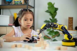 STEM education concept. Asian students learn at home by coding robot arms in STEM, mathematics engineering science technology computer code in robotics for kids' concepts photo
