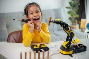 STEM education concept. Asian students learn at home by coding robot arms in STEM, mathematics engineering science technology computer code in robotics for kids' concepts. photo