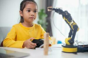 STEM education concept. Asian students learn at home by coding robot arms in STEM, mathematics engineering science technology computer code in robotics for kids' concepts. photo
