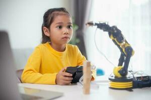 STEM education concept. Asian students learn at home by coding robot arms in STEM, mathematics engineering science technology computer code in robotics for kids' concepts. photo