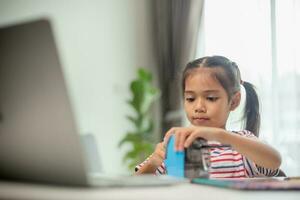 Student child girl using Pencil sharpener while doing homework. education concept. photo