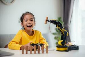 STEM education concept. Asian students learn at home by coding robot arms in STEM, mathematics engineering science technology computer code in robotics for kids' concepts. photo