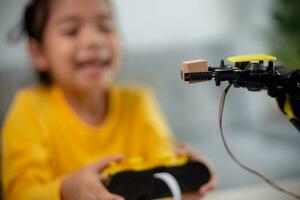 STEM education concept. Asian students learn at home by coding robot arms in STEM, mathematics engineering science technology computer code in robotics for kids' concepts. photo