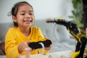 STEM education concept. Asian students learn at home by coding robot arms in STEM, mathematics engineering science technology computer code in robotics for kids' concepts. photo
