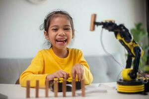 STEM education concept. Asian students learn at home by coding robot arms in STEM, mathematics engineering science technology computer code in robotics for kids' concepts. photo