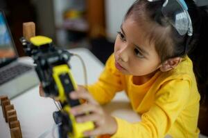 STEM education concept. Asian students learn at home by coding robot arms in STEM, mathematics engineering science technology computer code in robotics for kids' concepts. photo