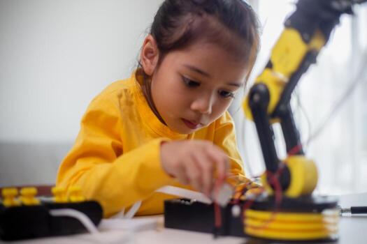 STEM education concept. Asian students learn at home by coding robot arms in STEM, mathematics engineering science technology computer code in robotics for kids' concepts. photo
