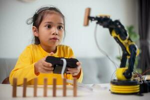 STEM education concept. Asian students learn at home by coding robot arms in STEM, mathematics engineering science technology computer code in robotics for kids' concepts. photo