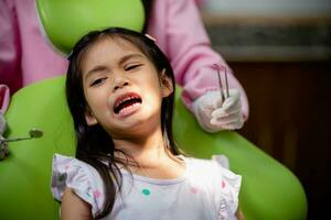 pequeño asiático muchachas dientes son sano en el dental oficina. dental cuidado, dentista cuidado. foto