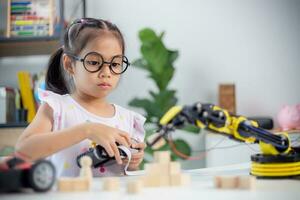 STEM education concept. Asian students learn at home by coding robot arms in STEM, mathematics engineering science technology computer code in robotics for kids' concepts photo