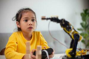 STEM education concept. Asian students learn at home by coding robot arms in STEM, mathematics engineering science technology computer code in robotics for kids' concepts. photo