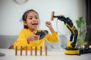 STEM education concept. Asian students learn at home by coding robot arms in STEM, mathematics engineering science technology computer code in robotics for kids' concepts. photo
