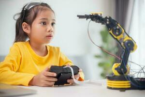 STEM education concept. Asian students learn at home by coding robot arms in STEM, mathematics engineering science technology computer code in robotics for kids' concepts. photo