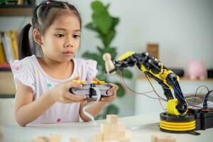 STEM education concept. Asian students learn at home by coding robot arms in STEM, mathematics engineering science technology computer code in robotics for kids' concepts photo