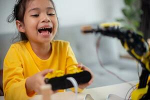 STEM education concept. Asian students learn at home by coding robot arms in STEM, mathematics engineering science technology computer code in robotics for kids' concepts. photo