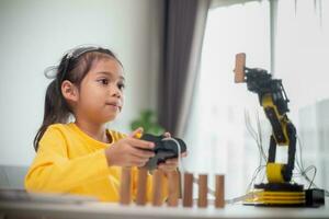 STEM education concept. Asian students learn at home by coding robot arms in STEM, mathematics engineering science technology computer code in robotics for kids' concepts. photo
