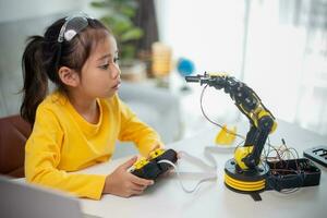STEM education concept. Asian students learn at home by coding robot arms in STEM, mathematics engineering science technology computer code in robotics for kids' concepts. photo