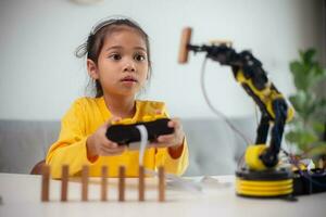 STEM education concept. Asian students learn at home by coding robot arms in STEM, mathematics engineering science technology computer code in robotics for kids' concepts. photo