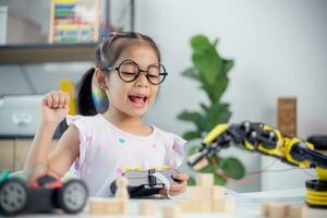 STEM education concept. Asian students learn at home by coding robot arms in STEM, mathematics engineering science technology computer code in robotics for kids' concepts photo
