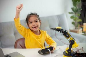 STEM education concept. Asian students learn at home by coding robot arms in STEM, mathematics engineering science technology computer code in robotics for kids' concepts. photo