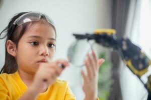 STEM education concept. Asian students learn at home by coding robot arms in STEM, mathematics engineering science technology computer code in robotics for kids' concepts. photo
