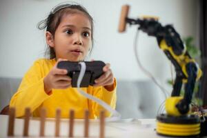 STEM education concept. Asian students learn at home by coding robot arms in STEM, mathematics engineering science technology computer code in robotics for kids' concepts. photo
