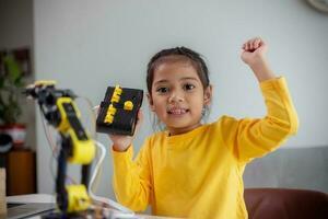 STEM education concept. Asian students learn at home by coding robot arms in STEM, mathematics engineering science technology computer code in robotics for kids' concepts. photo