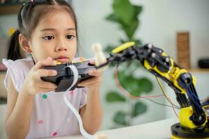 STEM education concept. Asian students learn at home by coding robot arms in STEM, mathematics engineering science technology computer code in robotics for kids' concepts photo