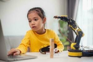 STEM education concept. Asian students learn at home by coding robot arms in STEM, mathematics engineering science technology computer code in robotics for kids' concepts. photo