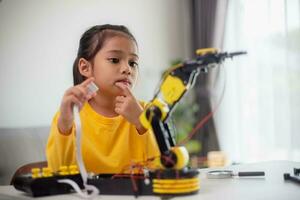 STEM education concept. Asian students learn at home by coding robot arms in STEM, mathematics engineering science technology computer code in robotics for kids' concepts. photo