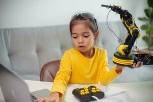 STEM education concept. Asian students learn at home by coding robot arms in STEM, mathematics engineering science technology computer code in robotics for kids' concepts. photo