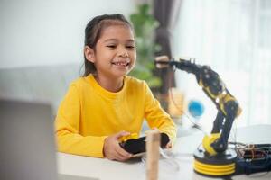 STEM education concept. Asian students learn at home by coding robot arms in STEM, mathematics engineering science technology computer code in robotics for kids' concepts. photo