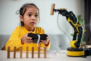 STEM education concept. Asian students learn at home by coding robot arms in STEM, mathematics engineering science technology computer code in robotics for kids' concepts. photo