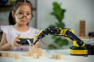 STEM education concept. Asian students learn at home by coding robot arms in STEM, mathematics engineering science technology computer code in robotics for kids' concepts photo
