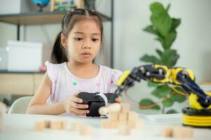 STEM education concept. Asian students learn at home by coding robot arms in STEM, mathematics engineering science technology computer code in robotics for kids' concepts photo