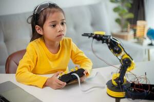 STEM education concept. Asian students learn at home by coding robot arms in STEM, mathematics engineering science technology computer code in robotics for kids' concepts. photo