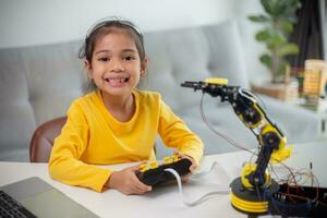 STEM education concept. Asian students learn at home by coding robot arms in STEM, mathematics engineering science technology computer code in robotics for kids' concepts. photo