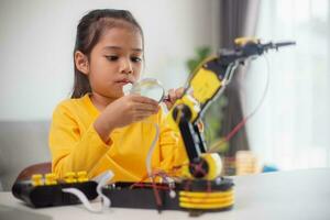 STEM education concept. Asian students learn at home by coding robot arms in STEM, mathematics engineering science technology computer code in robotics for kids' concepts. photo