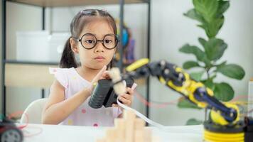 STEM education concept. Asian students learn at home by coding robot arms in STEM, mathematics engineering science technology computer code in robotics for kids' concepts photo