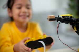 STEM education concept. Asian students learn at home by coding robot arms in STEM, mathematics engineering science technology computer code in robotics for kids' concepts. photo