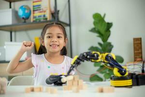 STEM education concept. Asian students learn at home by coding robot arms in STEM, mathematics engineering science technology computer code in robotics for kids' concepts photo