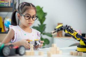 STEM education concept. Asian students learn at home by coding robot arms in STEM, mathematics engineering science technology computer code in robotics for kids' concepts photo