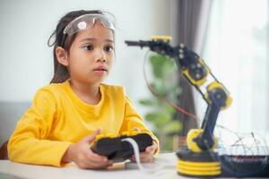 STEM education concept. Asian students learn at home by coding robot arms in STEM, mathematics engineering science technology computer code in robotics for kids' concepts. photo